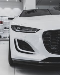 Close-up of a luxurious white sports car front in a modern showroom.