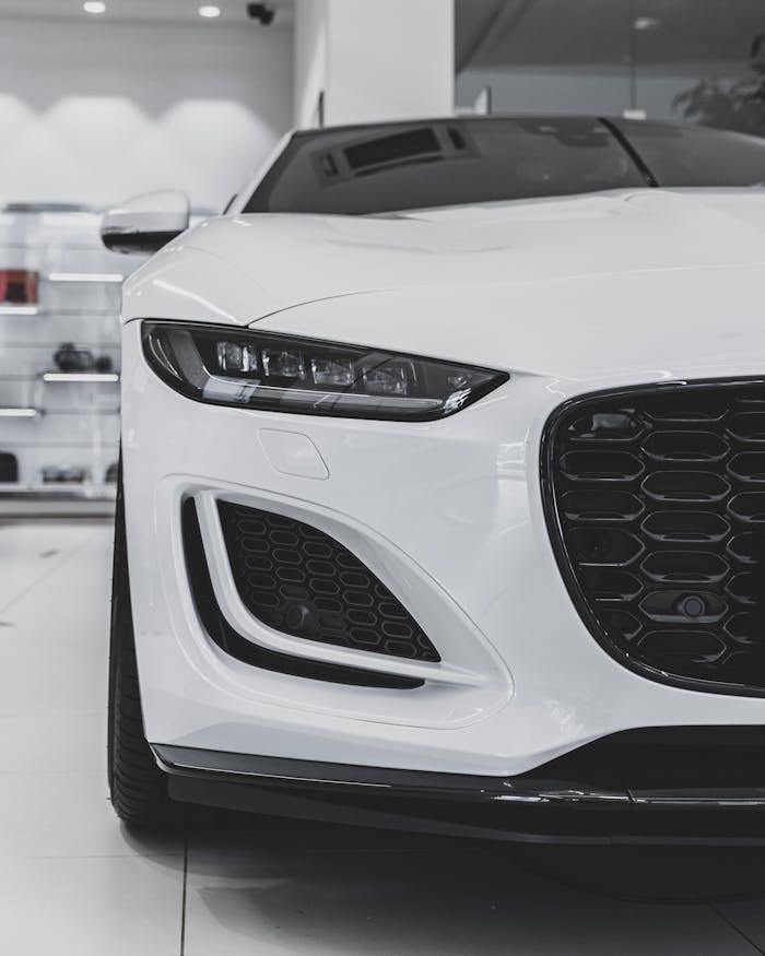 Close-up of a luxurious white sports car front in a modern showroom.