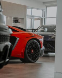 Sleek red and black Lamborghinis showcased in an elegant car showroom.